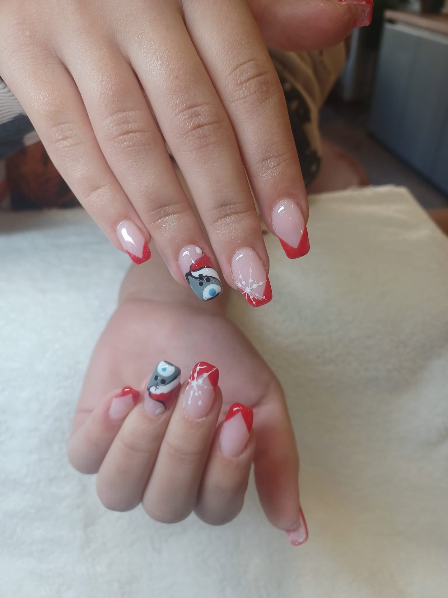 Festive red French tip nails with hand-painted character artwork