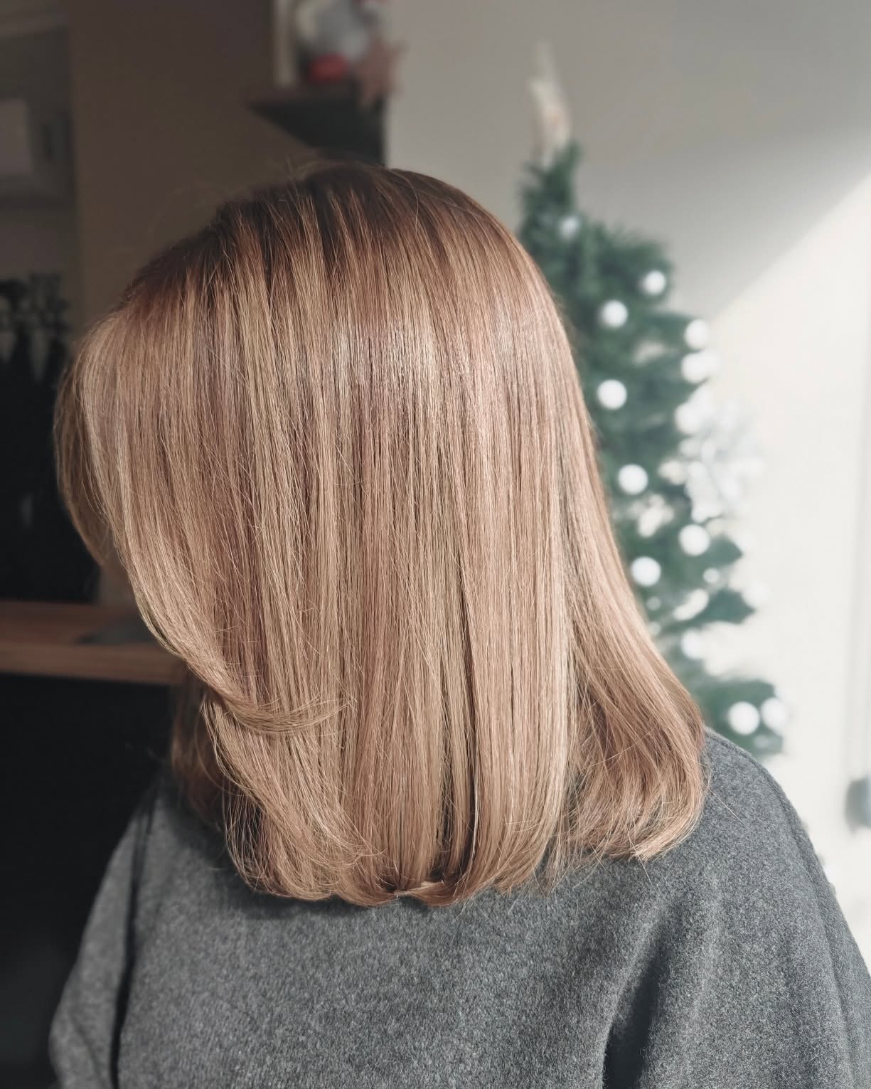 Smooth warm honey-blonde medium-length hair styling at Cafuné Hair Lounge