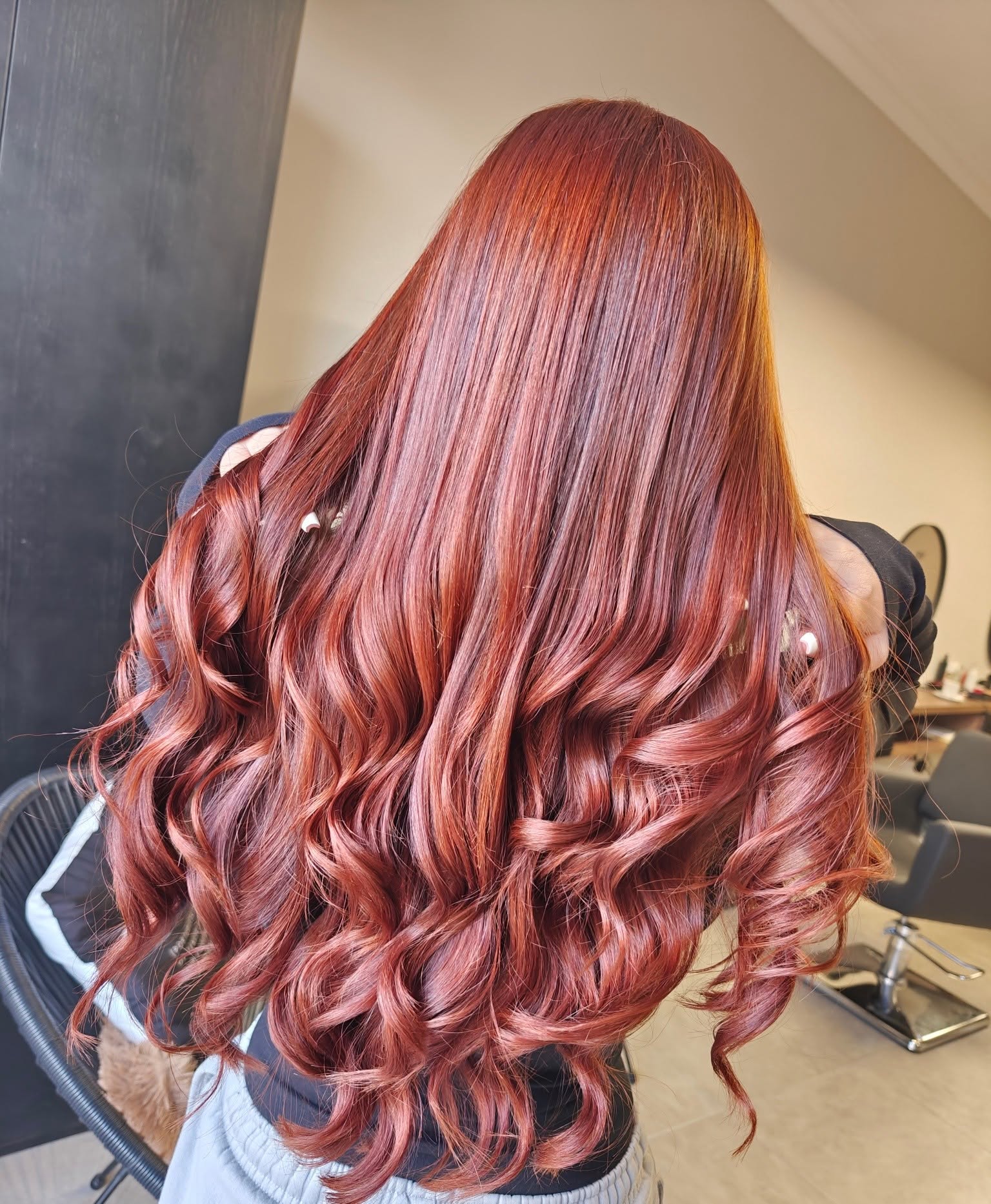 Vibrant copper-red long hair with glossy waves coloured in Xemxija, Malta